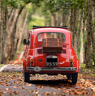 Single-seater race car navigating a sharp corner on a racetrack with red and white curbs.