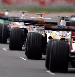 Group of six young adults collaborating around a laptop in a casual office setting.