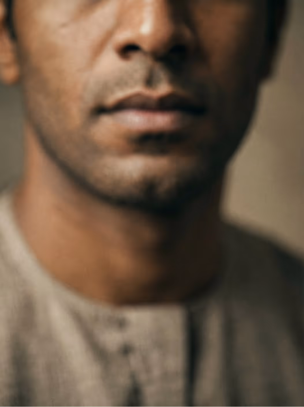 Close-up of a man's lower face, focusing on lips and jawline with subtle facial hair.