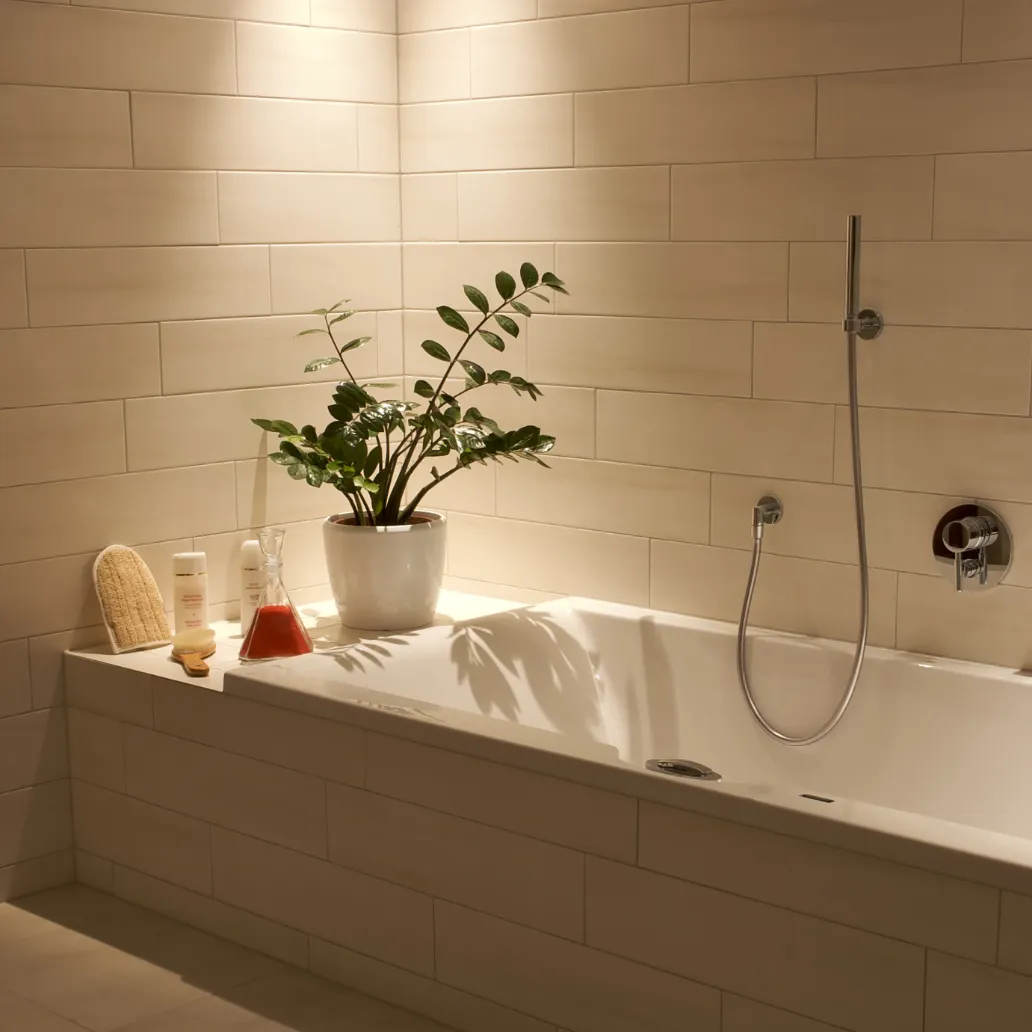Modern bathtub with chrome fixtures and wall-mounted shower, surrounded by beige tile and spa accessories.