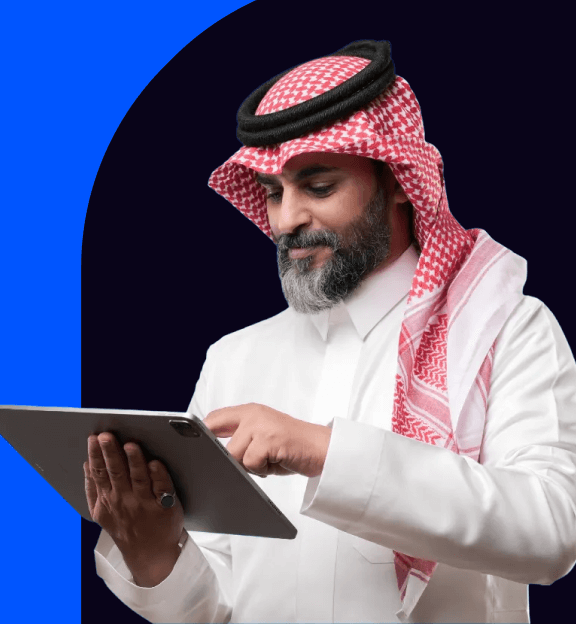 رجل يرتدي الثوب والغترة السعودية يستخدم جهاز لوحي بحجم كبير.
