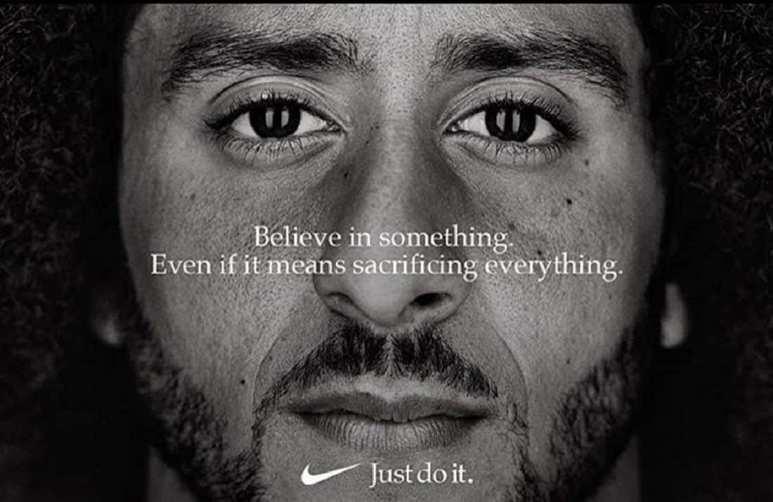 Gros plan en noir et blanc du visage d'un homme avec le texte « Croyez en quelque chose, même si cela signifie tout sacrifier » et le slogan Nike « Just do it ».