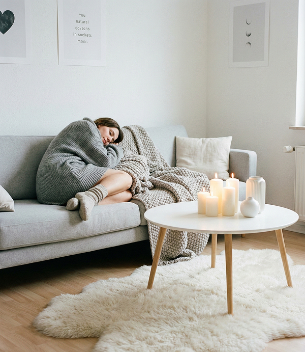 Bright and airy Nordic room with soft wool blankets, light wood, and a fireplace