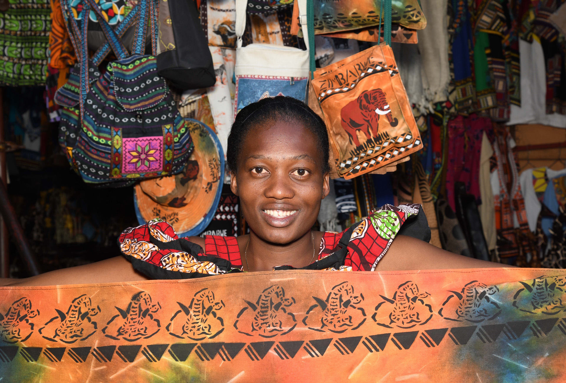 Handbedruckte Stoffe, Holzfiguren und Glasperlenschmuck gehören zu den typischen Souvenirs aus Simbabwe. Feilschen ist üblich und unterstützt lokale Händler.