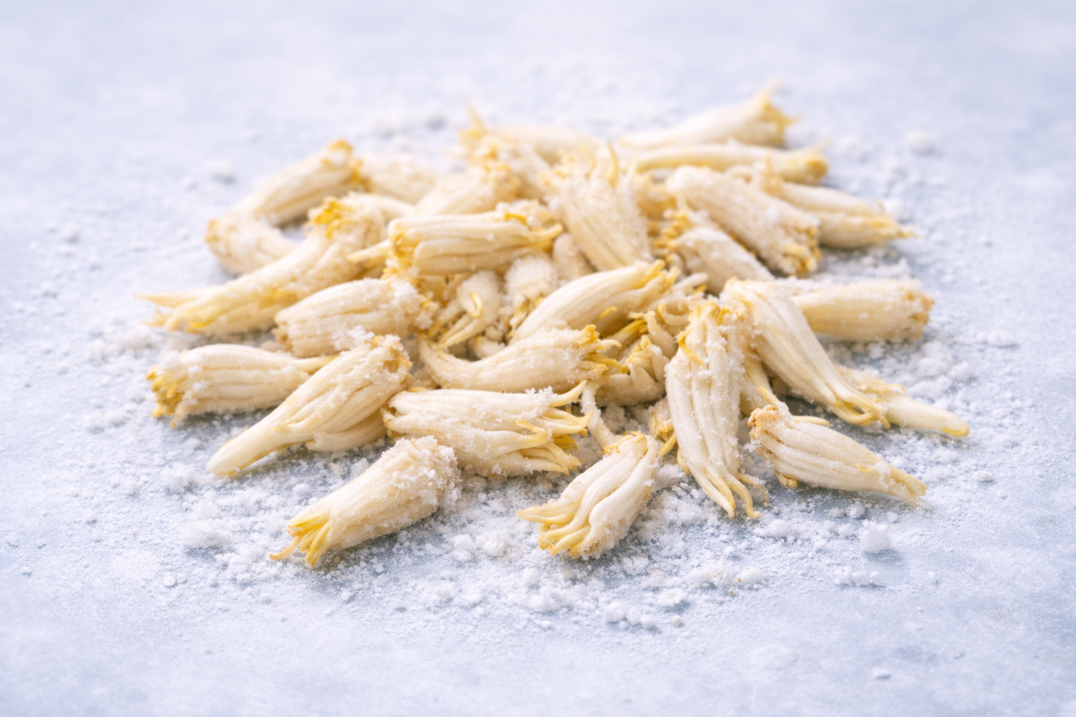 Close-up of frozen banana flower buds covered with frost on a cold surface.