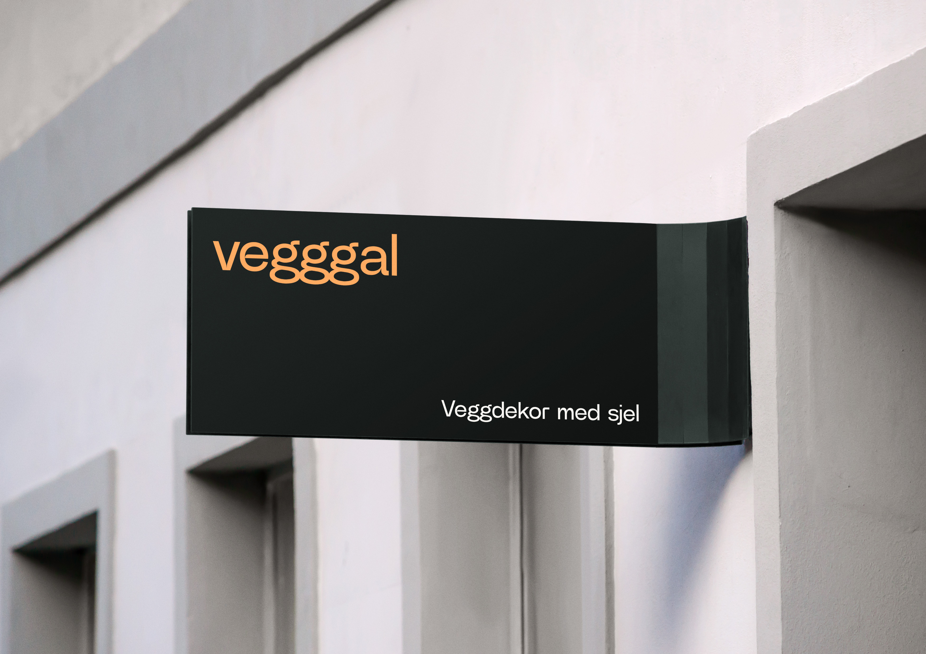 Sort fasadeskilt med oransje teksten vegggal og hvit teksten Veggdekor med sjel.