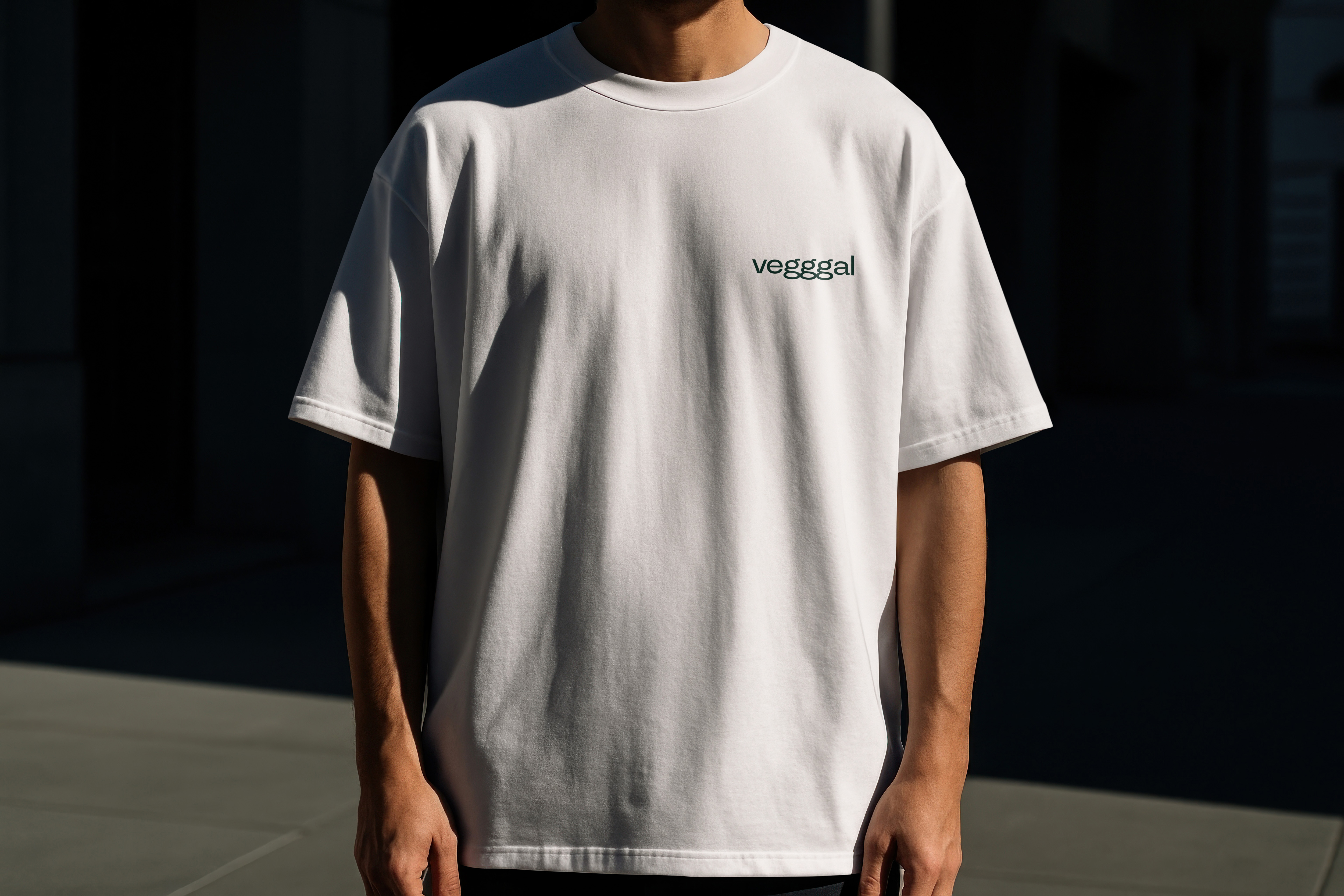 Person som bærer en hvit t-skjorte med teksten 'vegggal' på brystet.