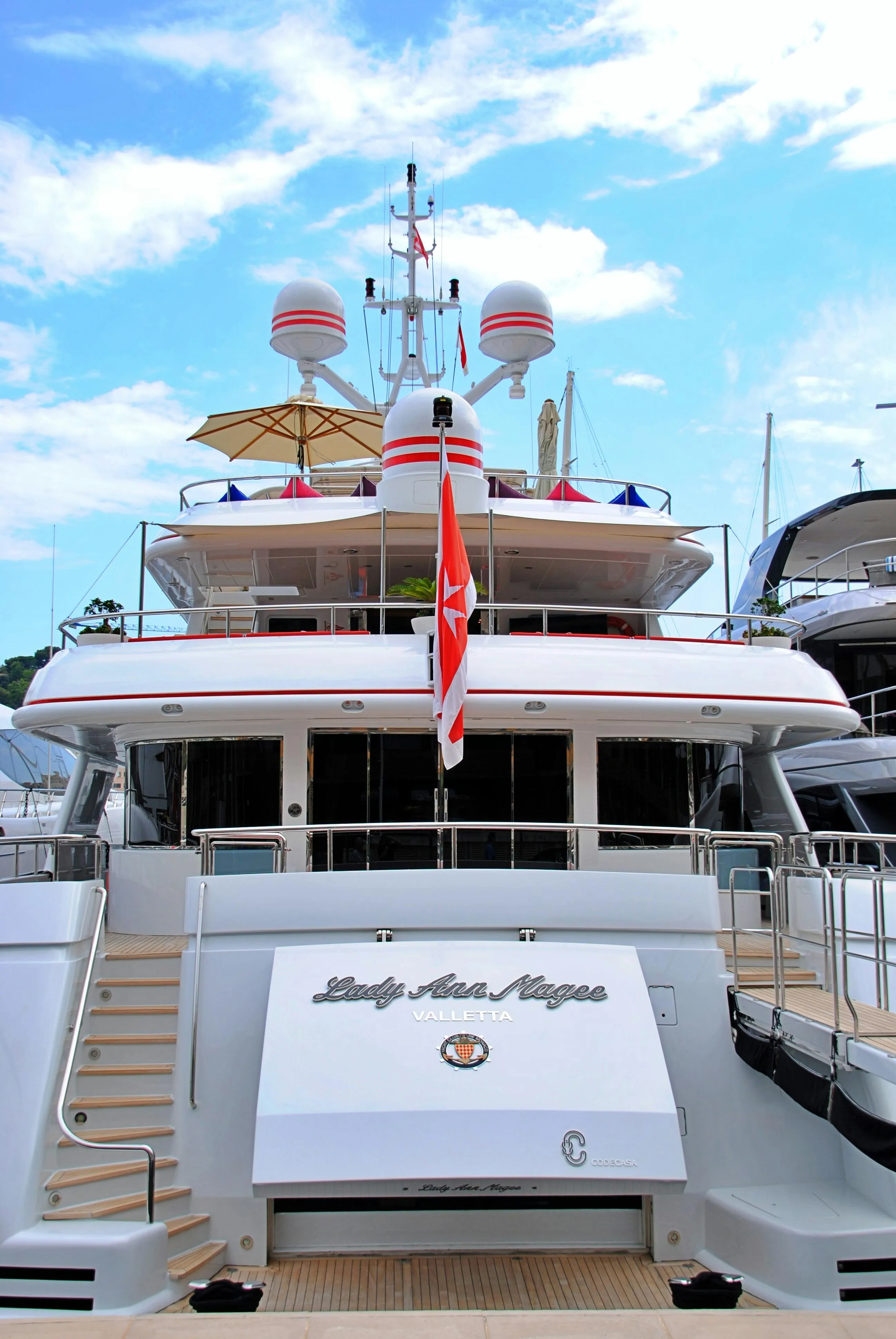 Poupe d'un yacht de luxe amarré dans une marina – location de yacht par notre conciergerie à Saint-Tropez