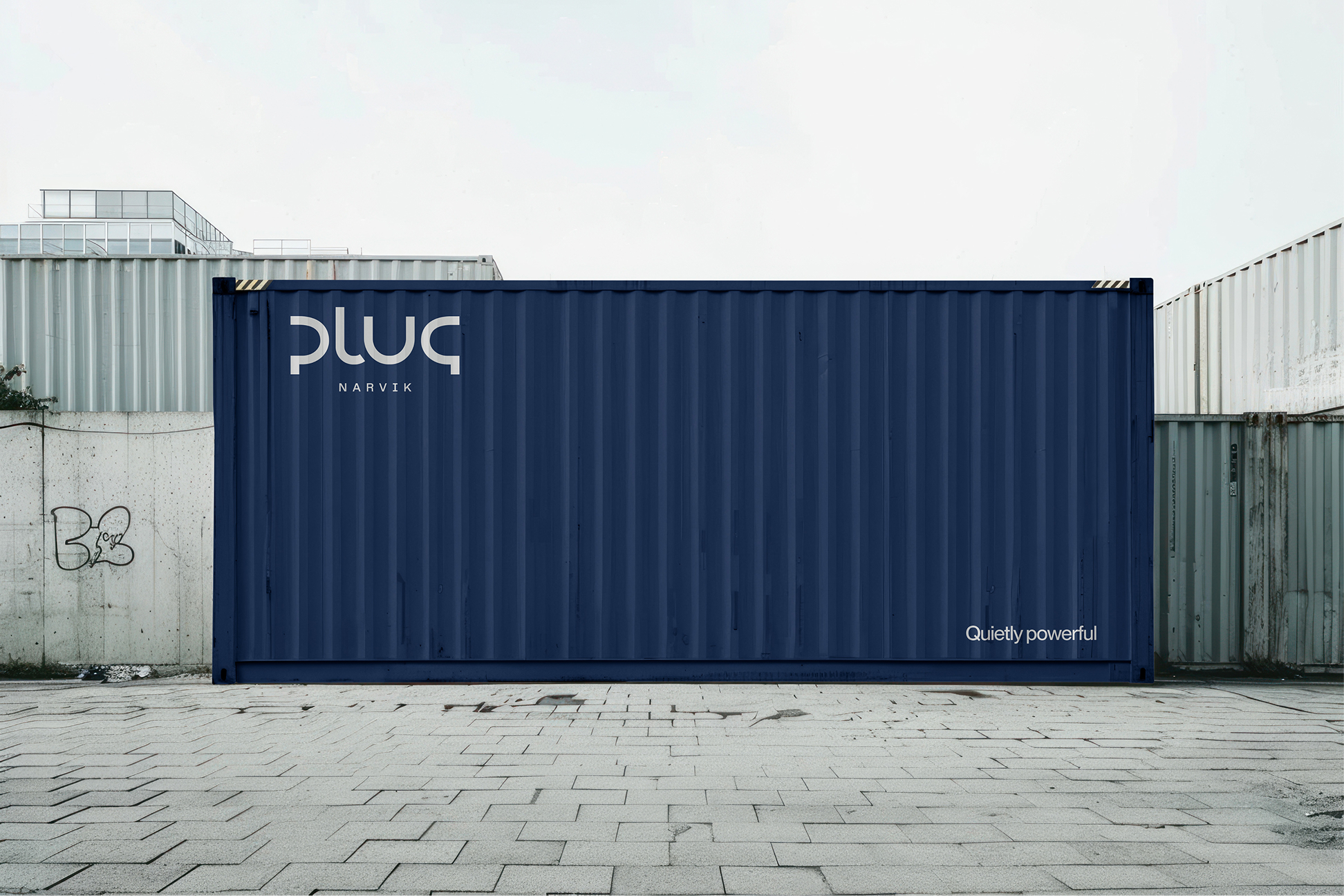 Blue shipping container with the text 'pluq Narvik' and 'Quietly powerful' on an industrial concrete and metal background.