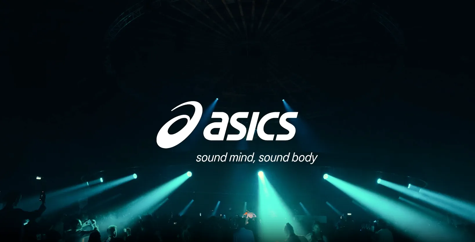 ASICS logo with the tagline 'sound mind, sound body' projected over a dark concert crowd illuminated by blue spotlights.