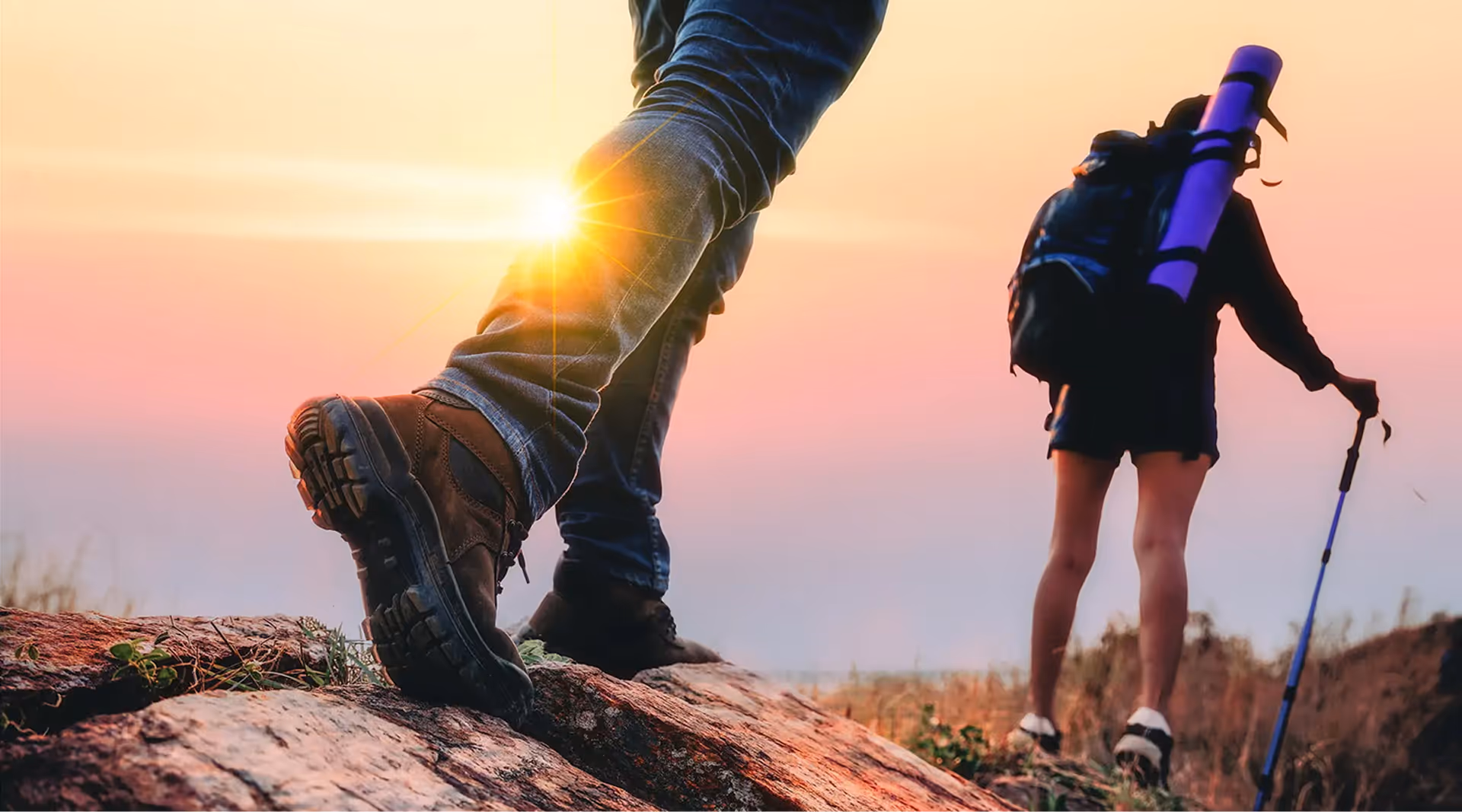 Close-up of hiking boots and trekkers exploring The Swift Water hotel trails during a golden sunset.