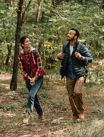 A couple hiking through the forest near The Swift Water hotel.