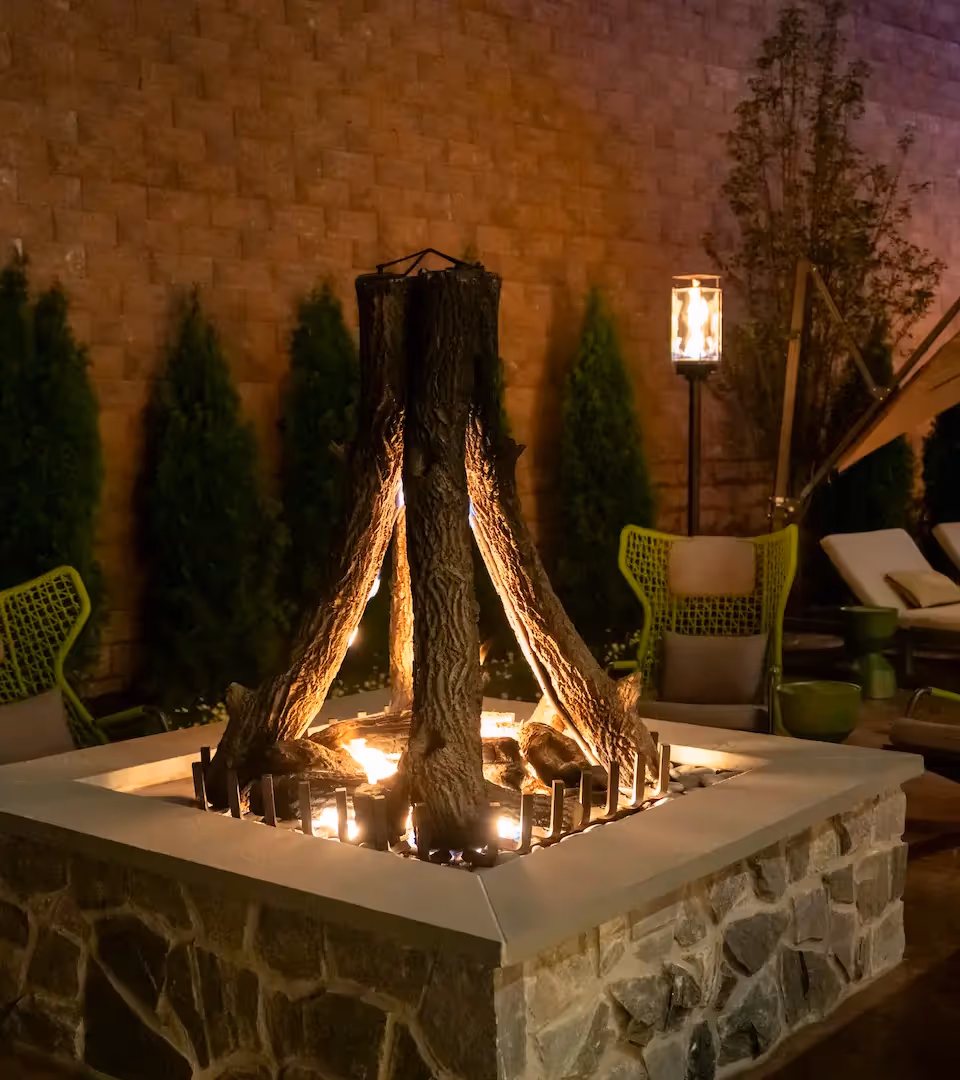 Modern indoor swimming pool with lounge chairs and floor-to-ceiling windows at The Swift Water hotel.