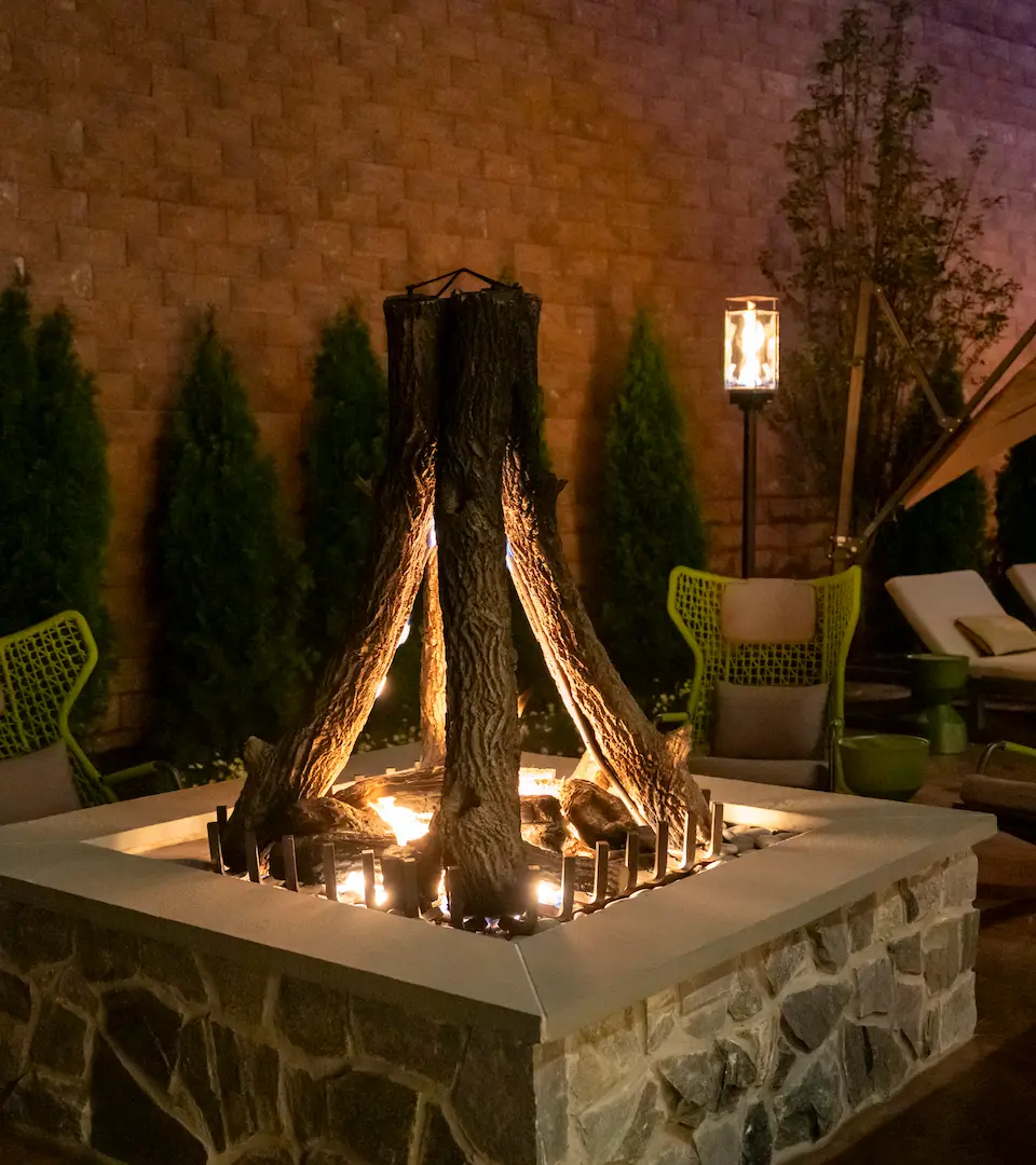 Modern indoor swimming pool with lounge chairs and floor-to-ceiling windows at The Swift Water hotel.