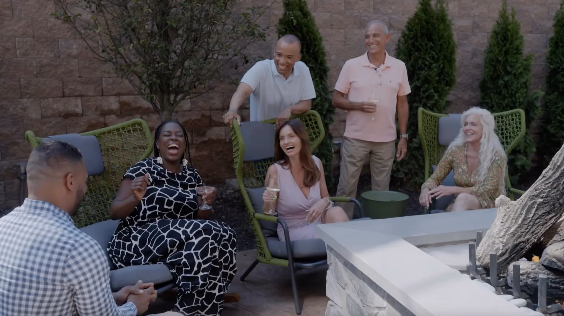 A group of friends sharing drinks and appetizers on the sun-drenched outdoor patio of The Swiftwater Hotel restaurant.