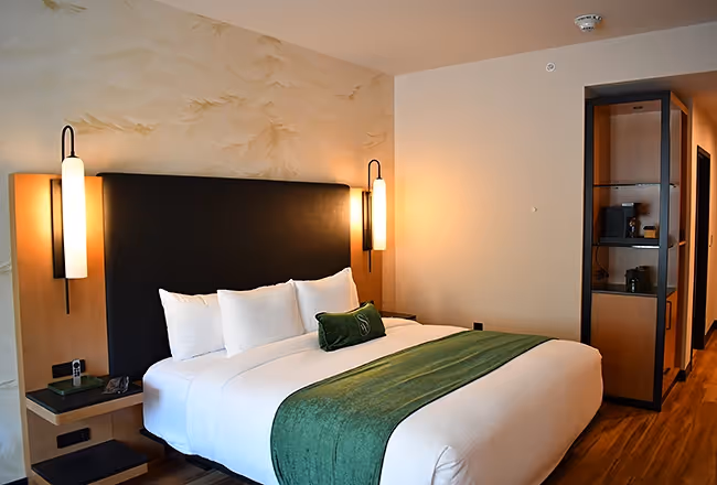 An elegant room at the Swiftwater featuring a black headboard, designer lamps and an integrated coffee station.