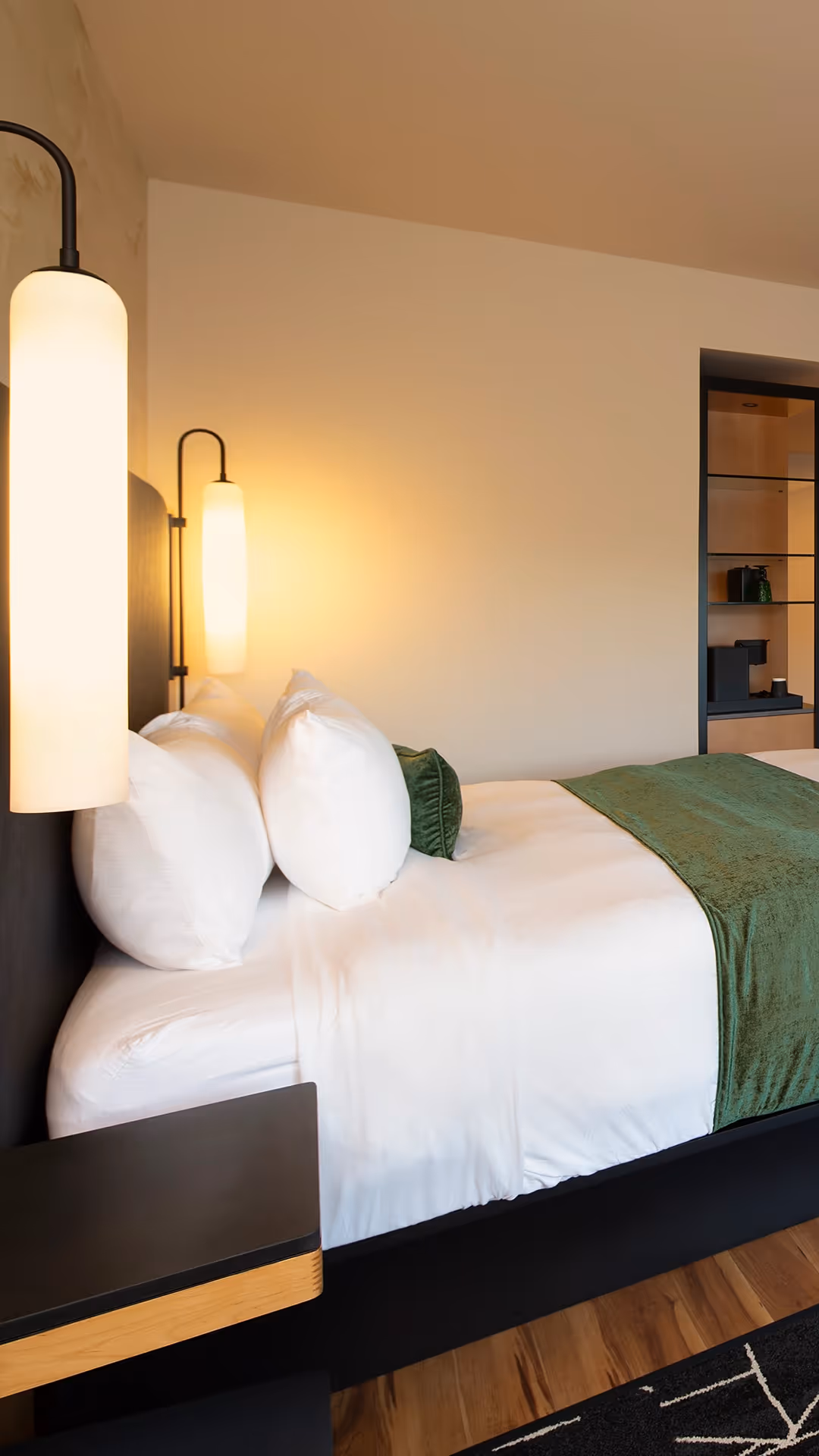 Close-up of the luxurious bedding and modern ambient lighting in a guest room at The Swiftwater.