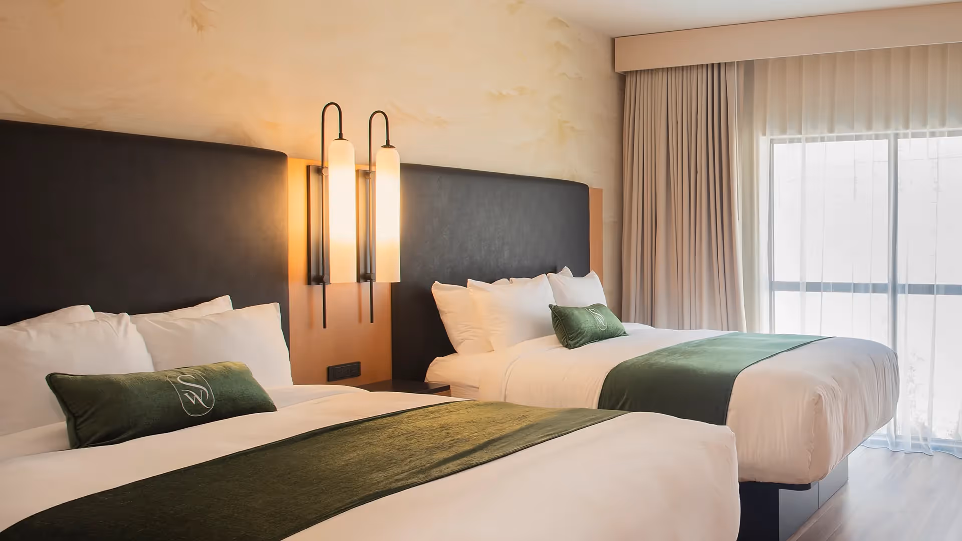 Close-up of the luxurious bedding and designer bedside lamps in a double guest room at The Swiftwater hotel