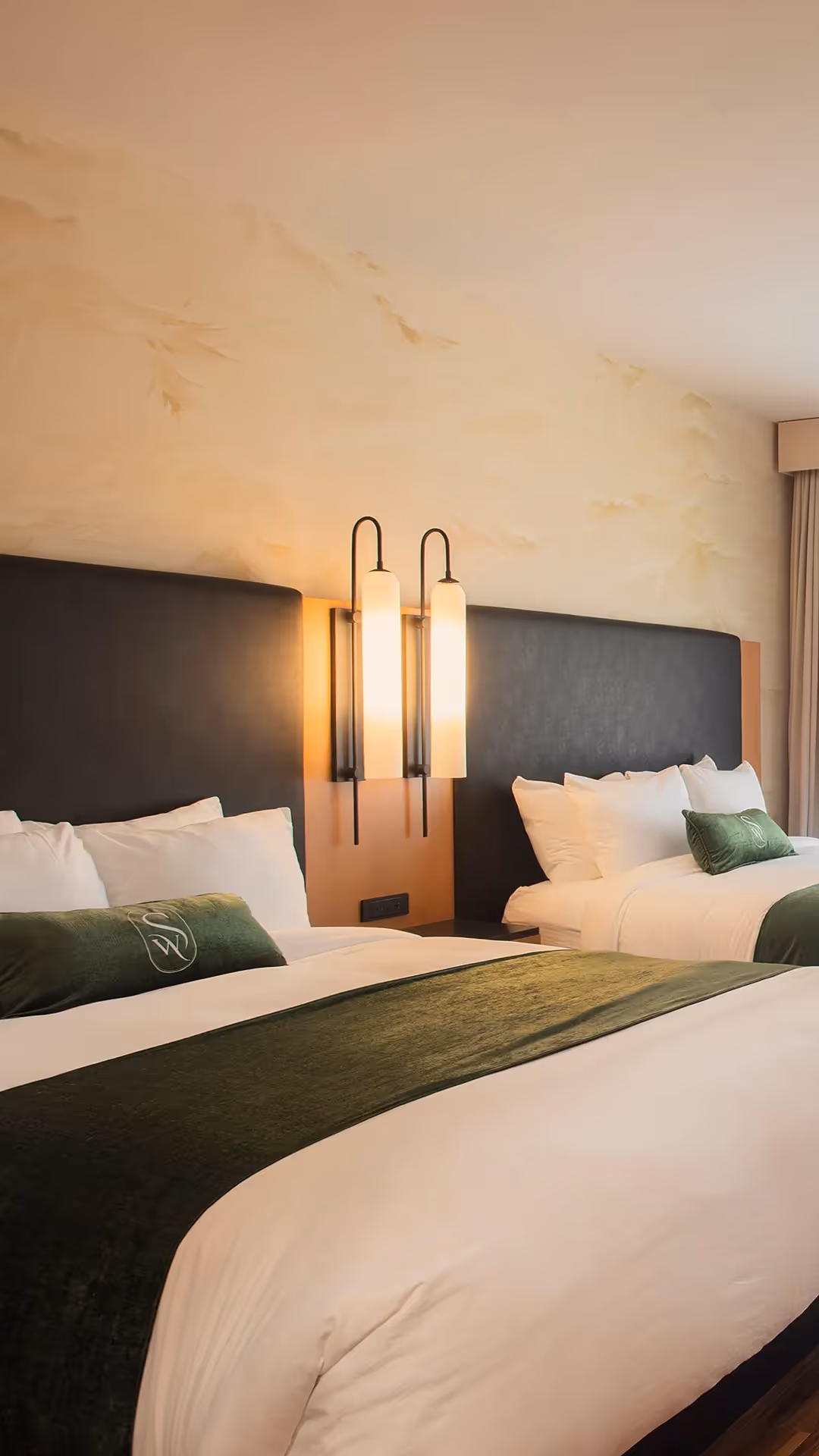 Close-up of the luxurious bedding and designer bedside lamps in a double guest room at The Swiftwater hotel