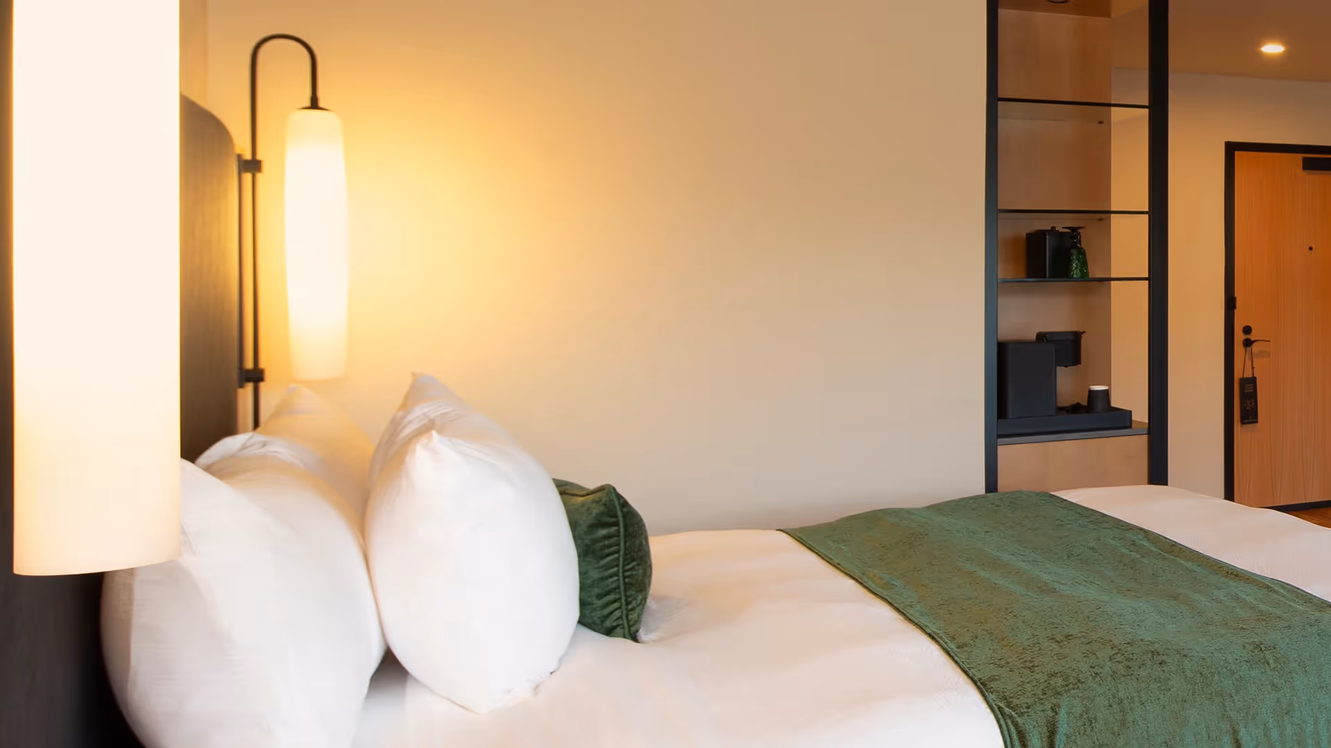 Close-up of the luxurious bedding and modern ambient lighting in a guest room at The Swiftwater.