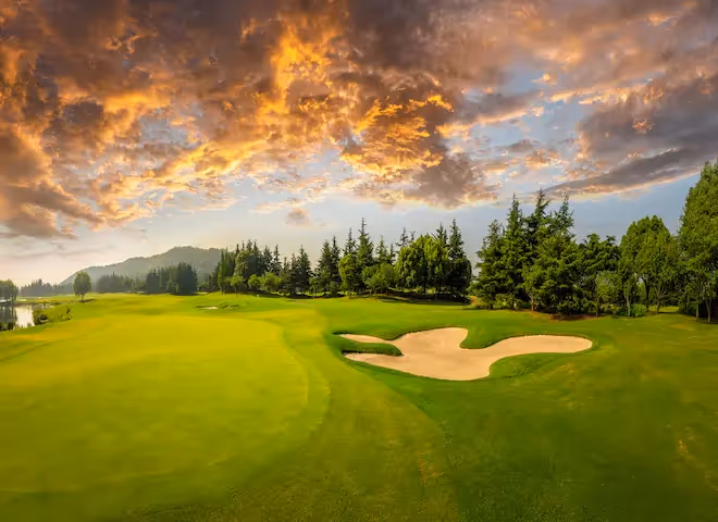 A golfer teeing off on a lush green golf course near The Swiftwater Hotel, showcasing the premium sports and leisure activities available for guests.