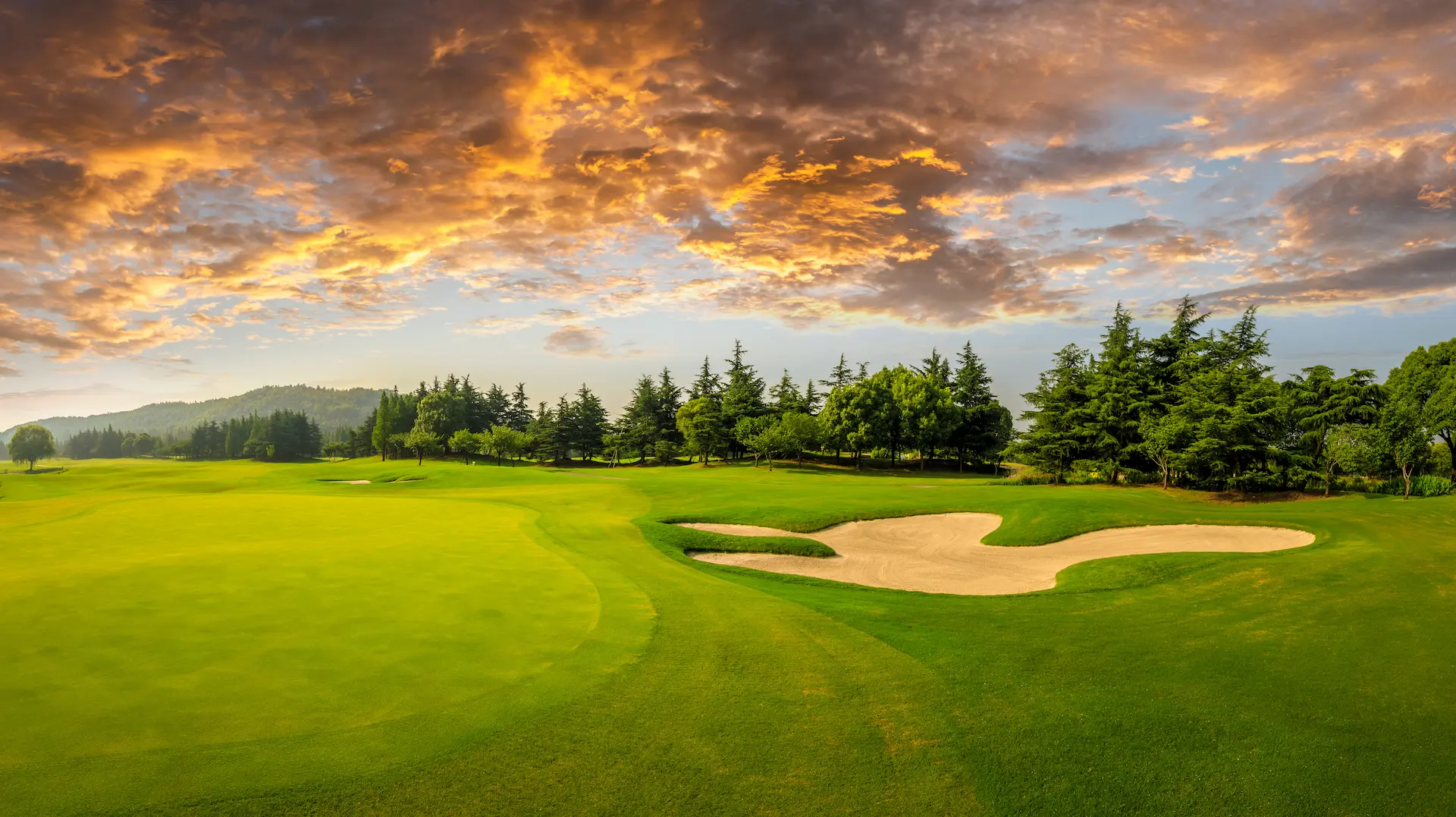 A golfer teeing off on a lush green golf course near The Swiftwater Hotel