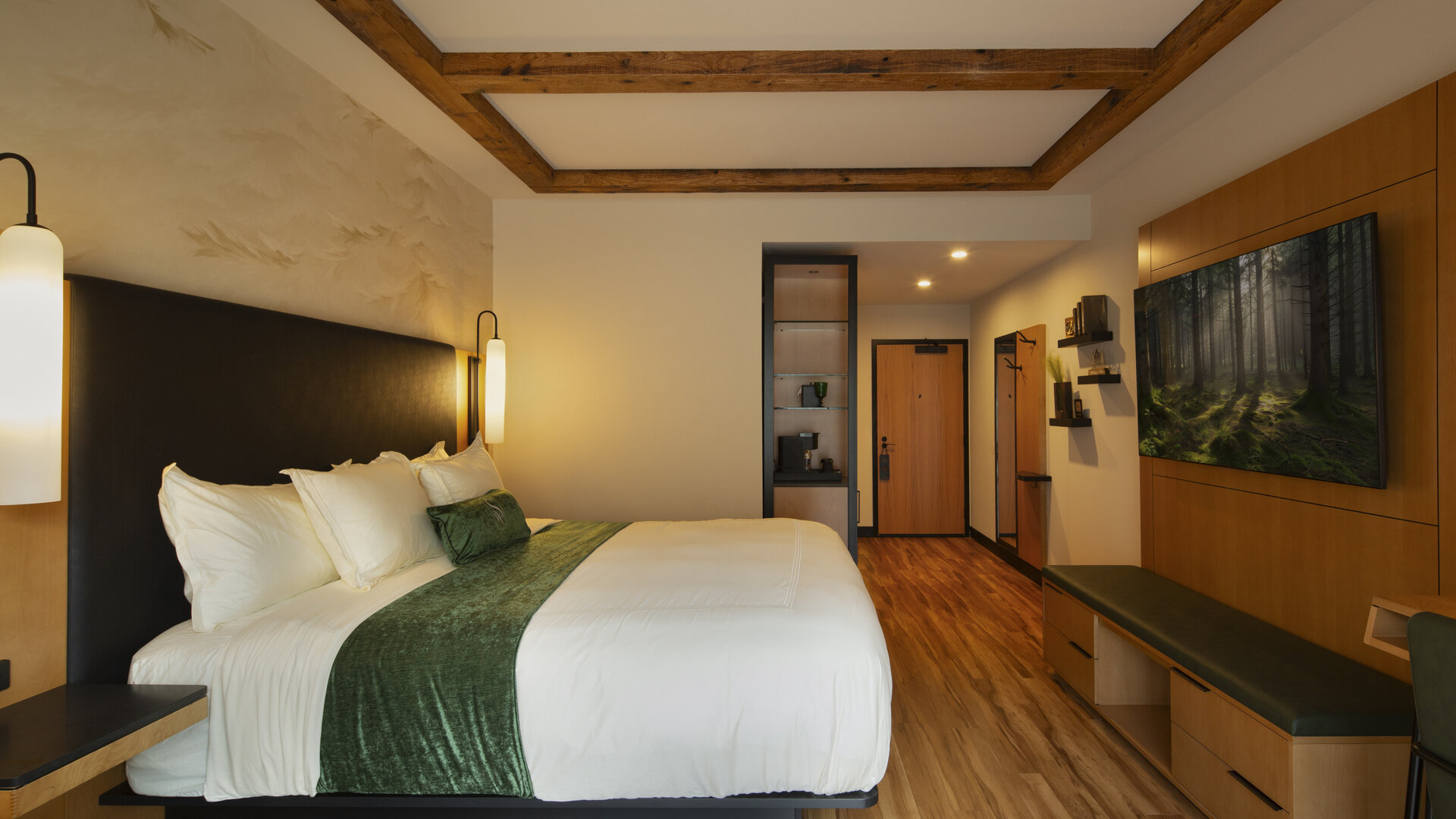 Concierge King suite at The Swiftwater featuring a plush king bed, dark wood accents, and forest-inspired decor for couples visiting the Pocono Mountains.
