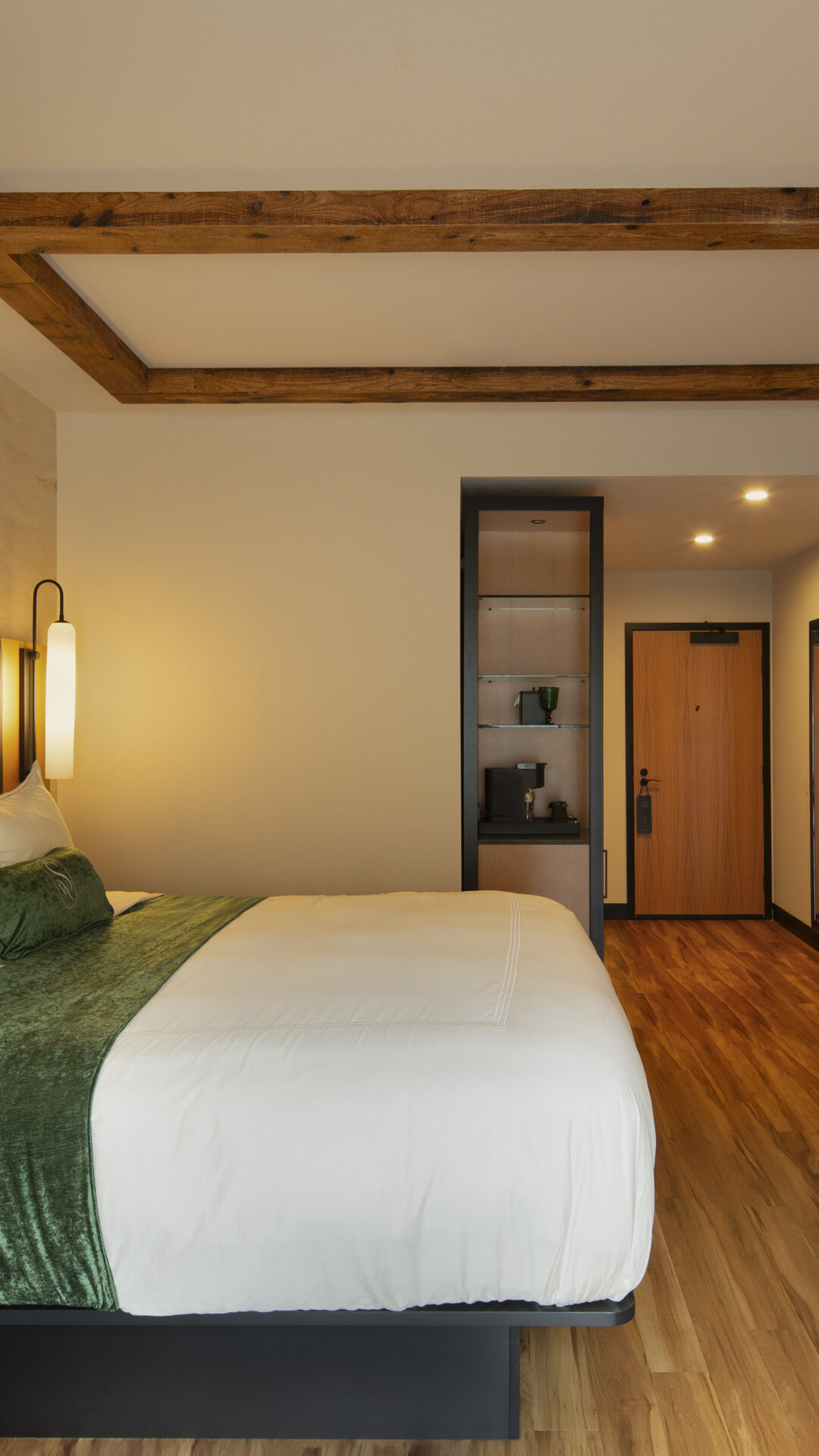 Concierge King suite at The Swiftwater featuring a plush king bed, dark wood accents, and forest-inspired decor for couples visiting the Pocono Mountains.