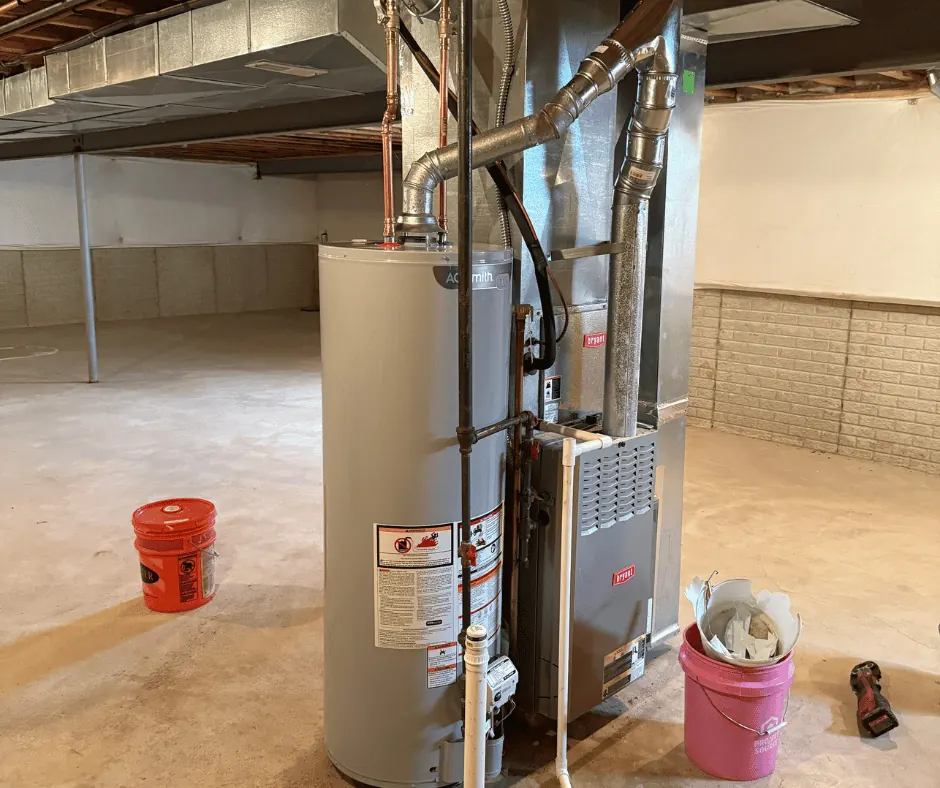 Red fire hydrant valves connected by a chain and secured with a padlock on a ground covered with brown mulch.