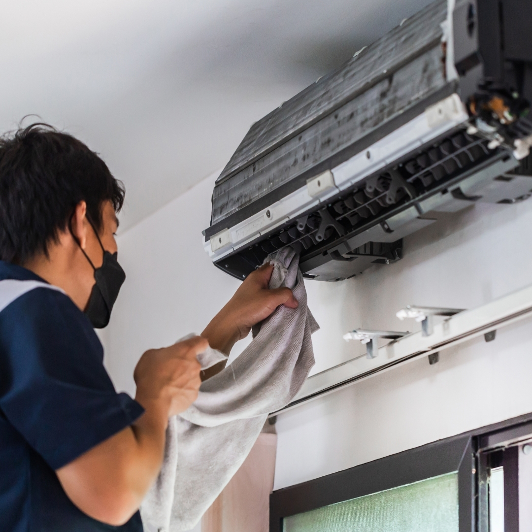 Technician cleaning indoor AC unit during professional AC repair in Columbus OH.