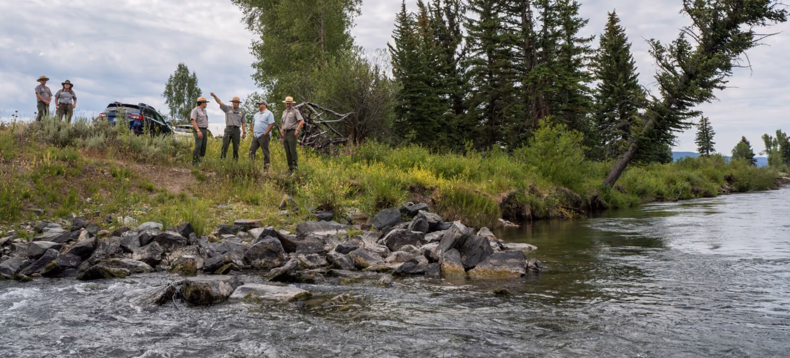 Grand Teton staff evaluate riverbank erosion near the highway.