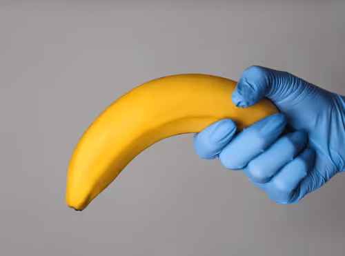 Man sitting on the edge of a bed looking concerned about his sexual health