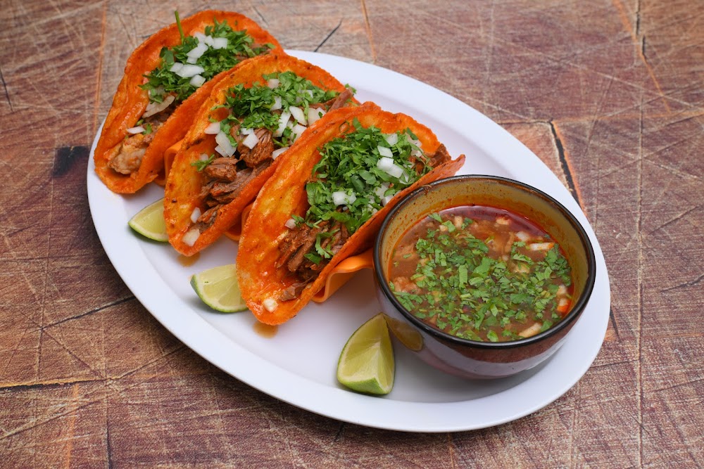A plate of food with a bowl of soup next to it.