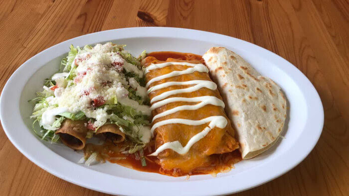 A plate of food with a salad, a burrito, and a quesadilla.