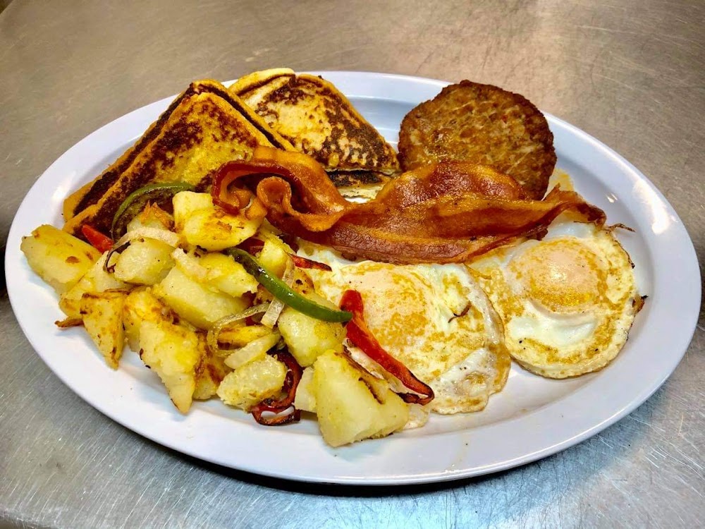 A plate of food with eggs, sausage, bacon, and potatoes.