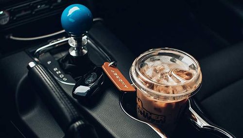 An iced coffee drink held in a car