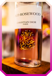 Close-up of Christian Dior Oud Rosewood perfume bottle with Arabic calligraphy on the glass.