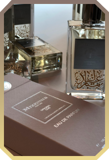 Close-up of Mizensir Oud Eau de Parfum bottle with its brown packaging box beside it.