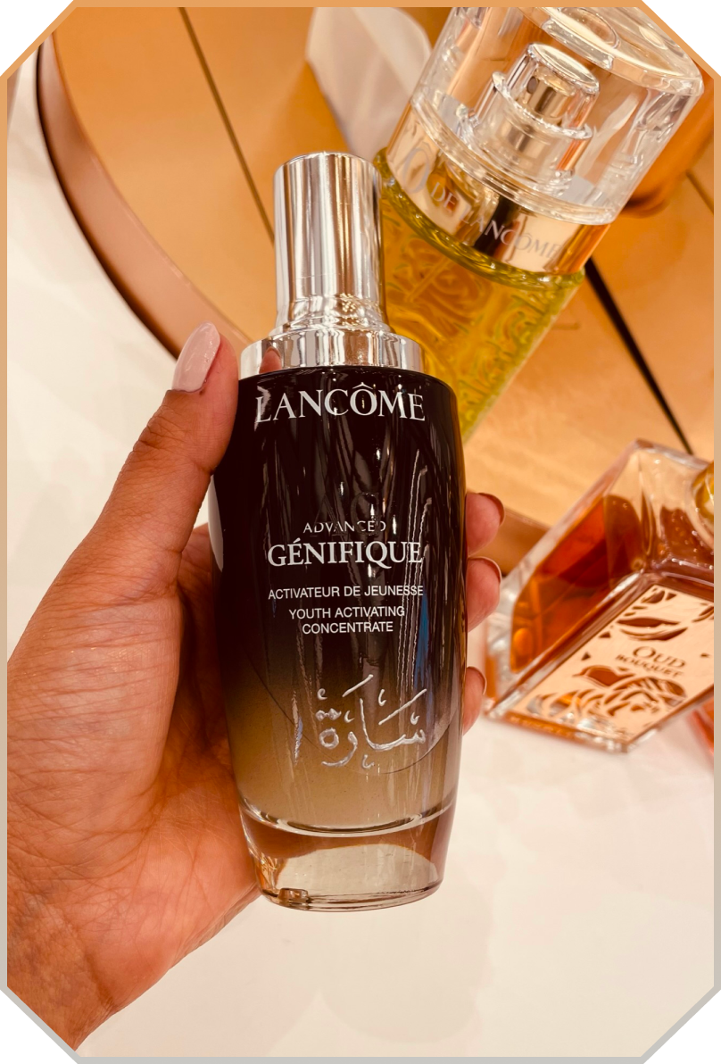 Hand holding a bottle of Lancôme Advanced Génifique Youth Activating Concentrate serum.