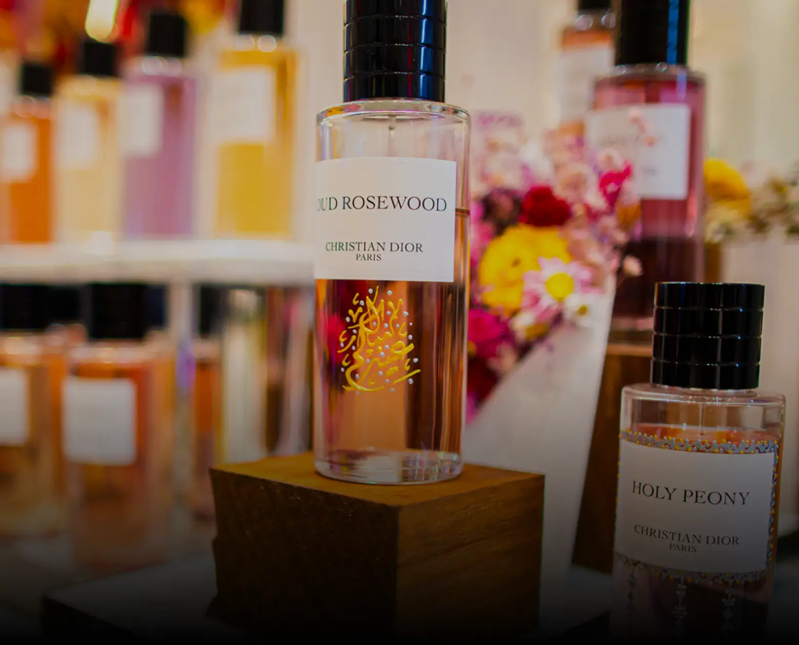 Close-up of a Dior Oud Rosewood perfume bottle with Arabic calligraphy on the glass.