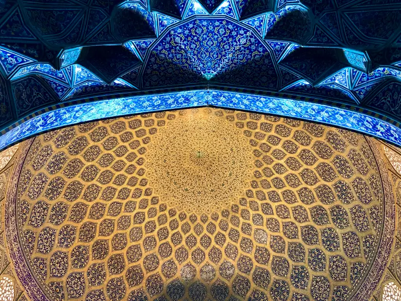 Intricately patterned blue and gold dome ceiling with symmetrical geometric and floral designs.