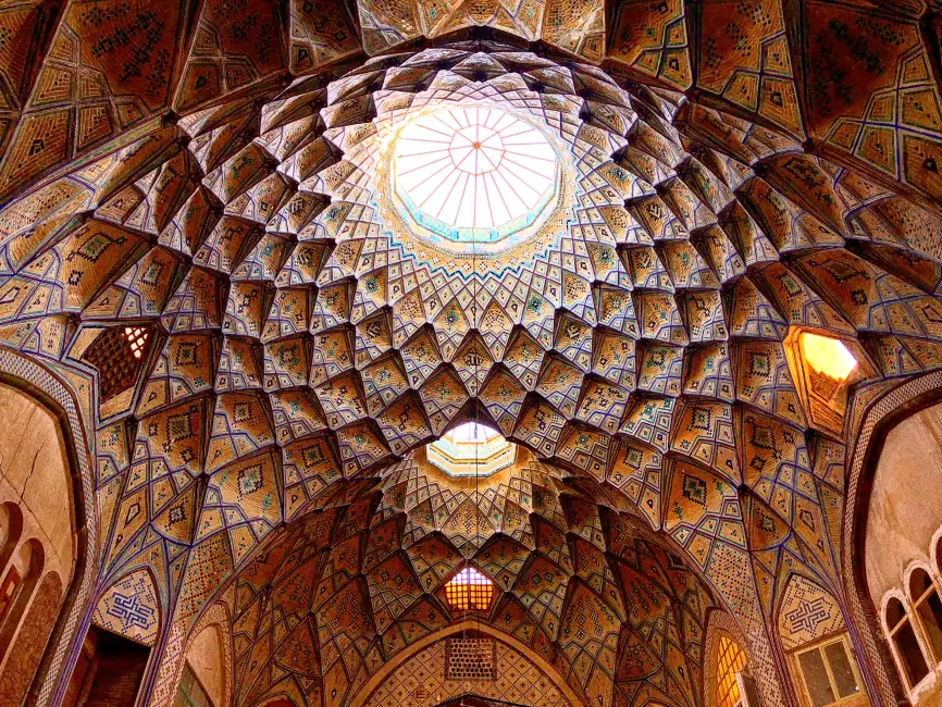 Intricately patterned Persian dome ceiling with geometric tilework and a central skylight.