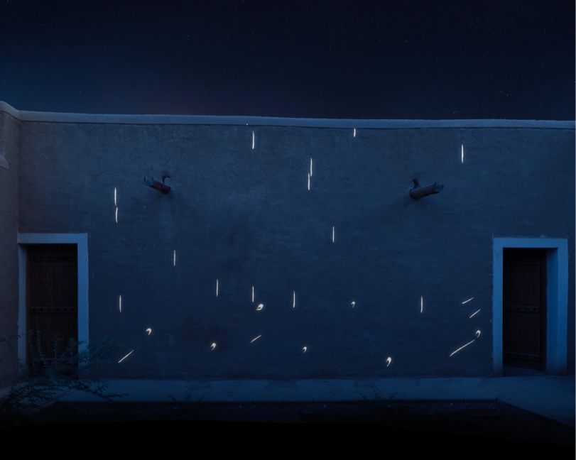 A wide shot of a dark stone building at night featuring a minimalist light projection of scattered white lines and abstract shapes across the wall.
