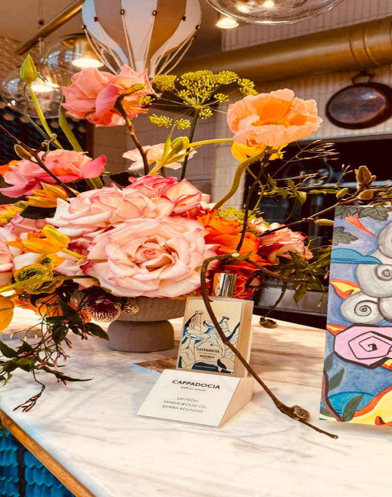 Lifestyle shot of a pink rose floral arrangement on a marble counter in a boutique setting.