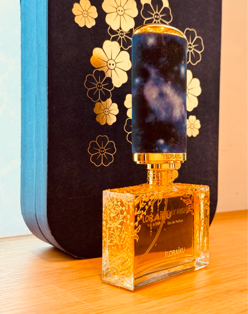 Floraïku I Am Coming Home fragrance bottle with gold floral engravings and a blue patterned case.