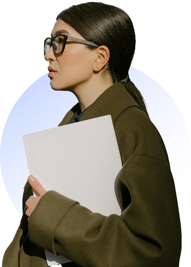 Woman with glasses and dark hair tied back, wearing a dark green coat, holding a blank white folder against a blue circular background.