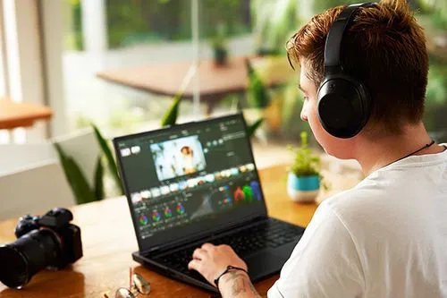 Hombre joven haciendo un un arreglo de color en DaVinci Resolve. Está usando los scopes para balancear la imagen.
