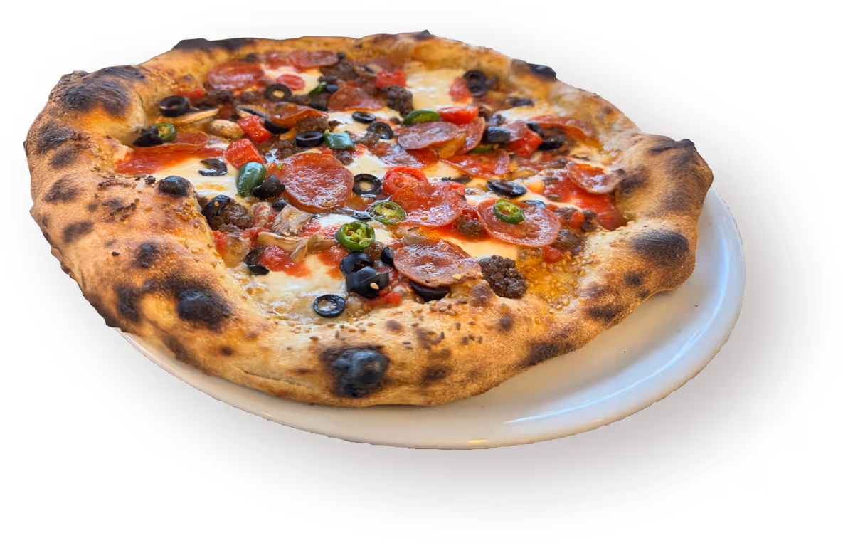 A wood-fired pizza on a white plate features pepperoni, black olives, green peppers, and melted cheese.