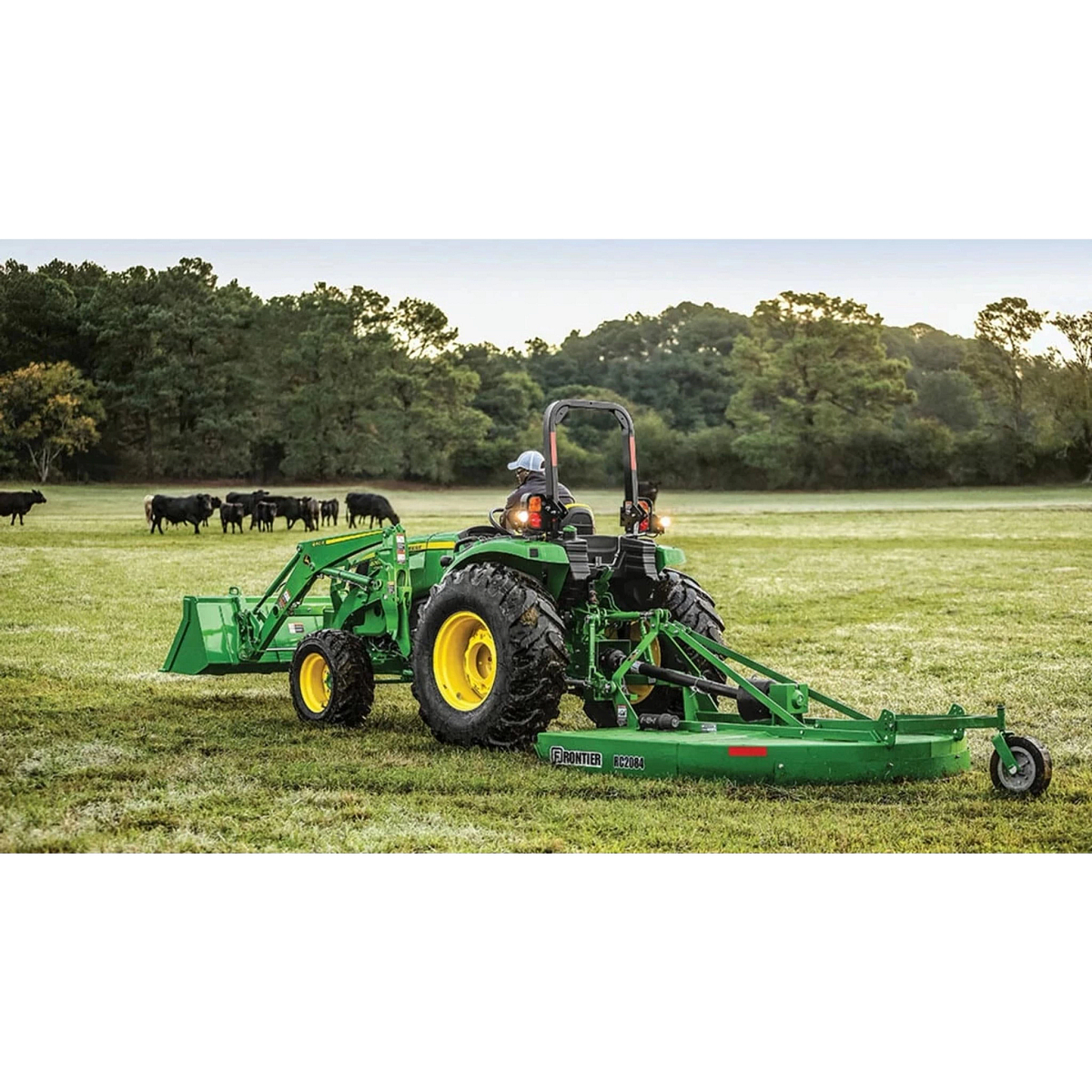 4066M Heavy Duty Compact Tractors with a farmer in a green tractor is standing in a field