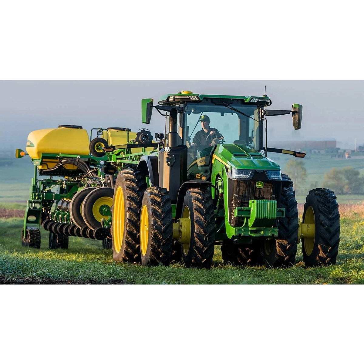8R 310 Tractor in a grassy field with a sprayer attachment